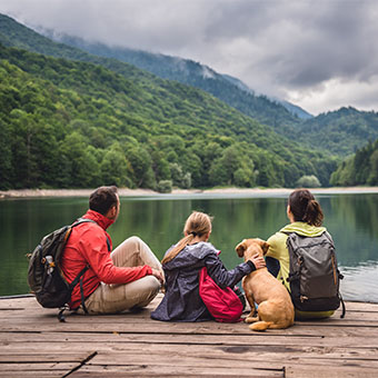 Family sitting on a lake dock
