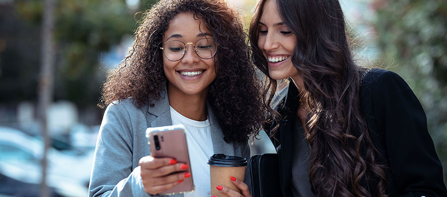 Two women looking at their smart phones.